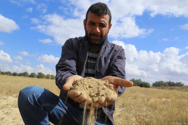 A Tunisian farmer showing dry land in Kairouan, in Tunisia, in October 2021. ANIS MILI / AFP